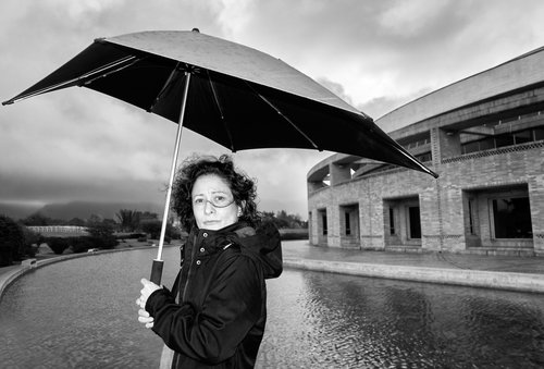 Fotografía de la autora Pilar Quintana sosteniendo una sombrilla en la Virgilio Barco a blanco y negro