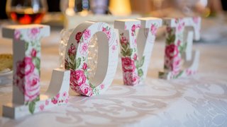 Fotografía de letras con la palabra Love de color blanco con rosas color rosa